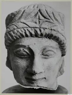Carved limestone head from Mersinaki with a fluted headdress and a band across the brow