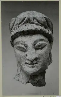 Limestone head from Kition with downcast eyes and a banded headdress, broken off at the neck