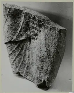 Limestone sculpture fragment from Vouni with carved ridges and a curled element on its upper surface