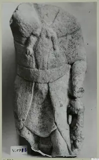 Limestone statuette fragment from Vouni: a torso with a broad belt and drapery folds, head and legs broken away.