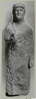 Limestone statue from Vouni of a standing figure in a long garment with hands at the body