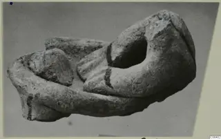 Broken terracotta fragment with an oval opening and a ridged section, shown on a grey backdrop