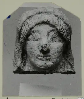 Terracotta head fragment with ridged hair framing a broad face, from Vouni