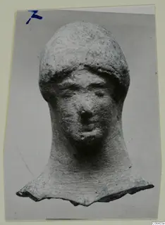 Terracotta head of a figure with a long neck and broken base, photographed on a grey mount
