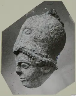 Limestone head from Vouni with a tall headdress, photographed on a card mount
