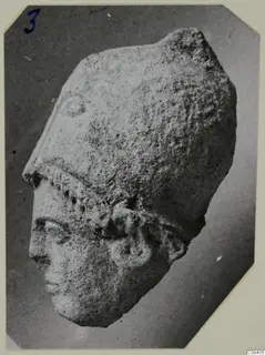 Limestone head from Vouni, photographed at an angle against a dark ground.