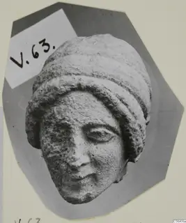 Limestone head fragment from Vouni of a woman wearing a layered headdress, nose chipped