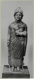 Standing limestone statue from Vouni, shown on a wooden plinth