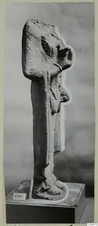 Limestone standing figure in side view, Vouni, on a wooden pedestal with a number label