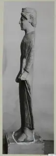 Limestone standing figure in profile, from Vouni, shown on a wooden block base