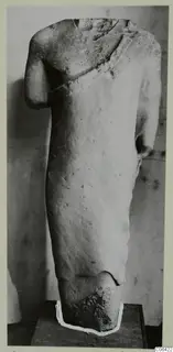 Limestone sculpture torso from Vouni, head and lower body broken off, shown on a dark base