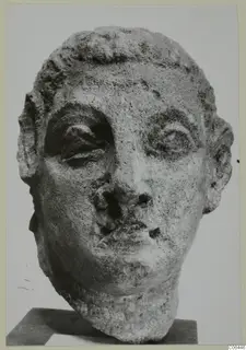 Carved head sculpture from Mersinaki with large eyes, short hair in rows and a chipped nose