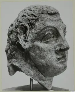 Carved stone head with short curled hair and a visible ear, turned to the right, from Mersinaki