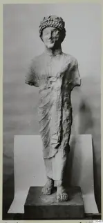 Limestone sculpture of a standing figure with a leafy wreath, arms broken off, on a dark plinth