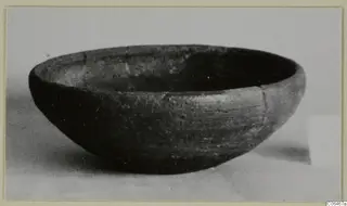 Pottery coarse ware bowl from Vouni, shown from the side on a pale surface