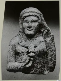 Limestone figurine of a bust with a hooded head and one arm bent across the chest, from Vouni