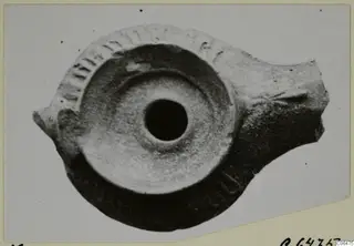 Terracotta oil lamp seen from above, with impressed decoration around the rim