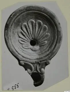 Terracotta oil lamp with a fan of raised petal shapes around its filling hole
