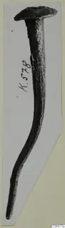 Bronze nail with a flat round head and a long, slightly curved shank, mounted on a card