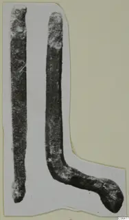 Two long corroded bronze rods, one bent into an L-shape, shown on a cut-out card mount