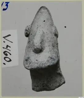 Terracotta figure fragment from Vouni with a pointed top, a raised central ridge and small side projections