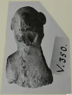Terracotta figurine of a head and shoulders, with a rounded knot of hair on top of the head