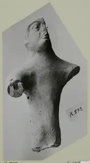 Terracotta figurine of a head and torso with one arm, photographed on a pale mount
