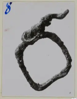 Corroded bronze ring fragment from Vouni with a bent, tapering extension at the top