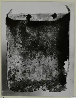 Corroded bronze shovel-like blade with a turned-up rim and two holes, from Vouni