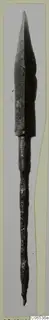 Bronze arrowhead from Vouni with a long tang, photographed upright against a pale grey background.
