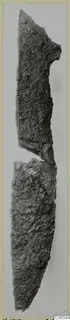 Two broken pieces of a heavily corroded iron knife, shown upright against a grey background