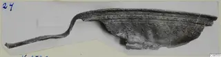 Bronze fragment with a curved, ridged rim and a thin strip extending to the left