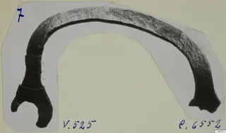 Curved bronze fragment with a forked end, on a cut card mount, from Vouni