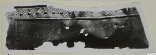 Fragment of a bronze sheet mounting with a row of bosses and wave-pattern relief along its upper edge