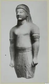 Limestone Neo-Cypriote statue of a standing figure with arm bands and a belt.