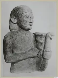 Limestone Cypro-Egyptian sculpture of a man holding a lyre-shaped stringed instrument, three-quarter view.
