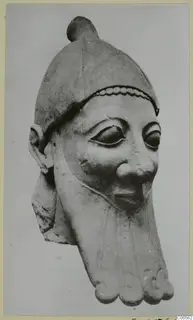 Limestone head of a bearded figure wearing a close-fitting cap with a knob on top and a beaded band