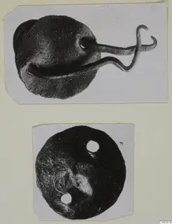 Two bronze fragments: a rounded piece with a bent wire loop, and a flat disc with two holes