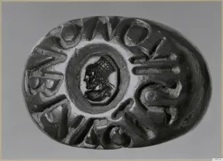 Oval seal or gem with a carved profile head in the centre, surrounded by raised letters around the edge
