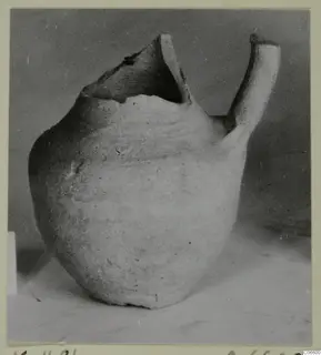 Pale plain pottery jug with a broken open top and a tubular handle, from Kition