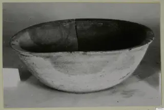 Pottery Plain White VI bowl seen from the side, with a crack running down its rim and interior