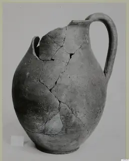 Coarse ware jug from Vouni, reassembled from fragments, with a tall loop handle and rounded body
