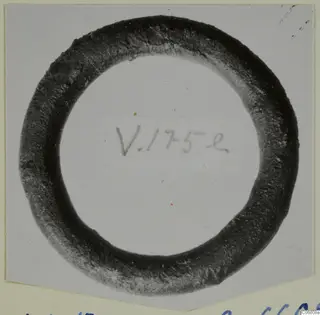 Bronze ring from Vouni, a dark corroded loop photographed face-on on a card mount