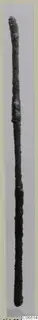 Long slender corroded metal rod from Vouni, shown upright