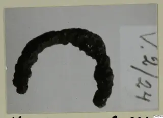 Corroded bronze finger ring, shown as an open loop on a grey background