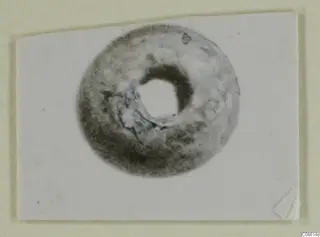 Ring-shaped bead from Vouni, photographed on a white card