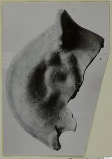 Fragment of a terracotta lamp with a pointed nozzle, from Mersinaki, photographed against a light background