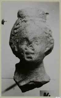 Terracotta figurine head with a tall headdress and wavy side hair, from Mersinaki