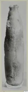 Tall, slender alabaster vessel with a flared rim, shown upright against a plain grey background
