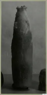 Tall, slender alabaster vessel with a flared rim, from Vouni, photographed against a grey backdrop